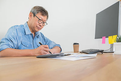 Man using mobile phone while sitting on table