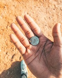 High angle view of human hand holding coin