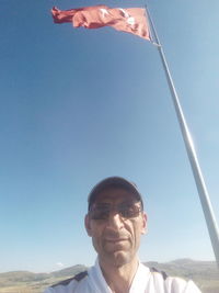 Mid adult man against clear blue sky