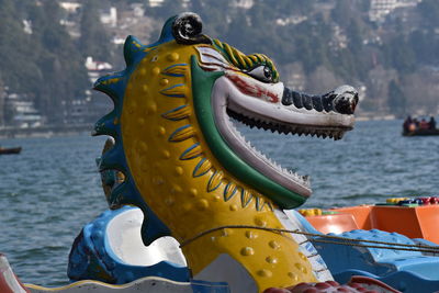 Close-up of yellow sculpture against sea