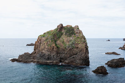 Rock formation on sea against sky