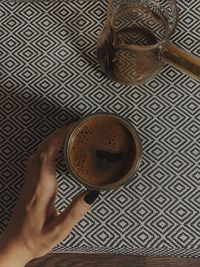 High angle view of hand holding coffee cup