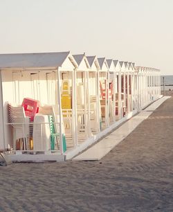 Deck chairs on beach against clear sky