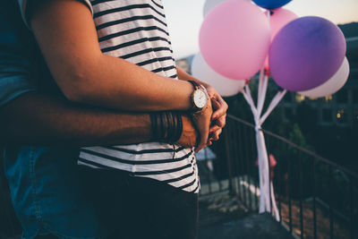 Midsection of couple embracing at building terrace