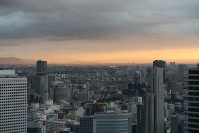 Aerial view of buildings in city against sky during sunset