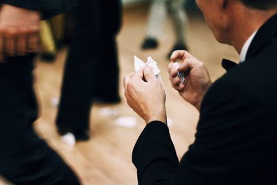 Midsection of man holding paper