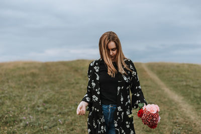 Woman standing on field against sky