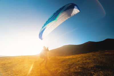 Low angle view of parachute against sky during sunset