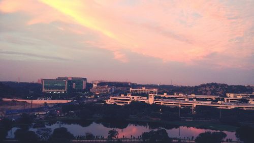 Illuminated cityscape against sky at sunset