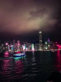 Illuminated buildings in city against sky at night