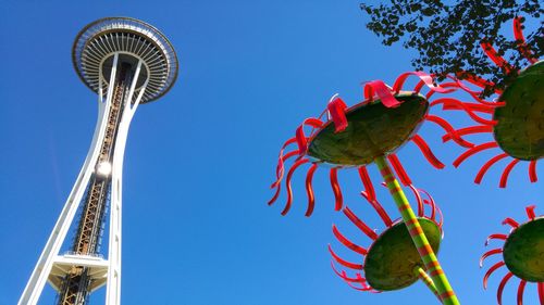 Low angle view of amusement park against blue sky