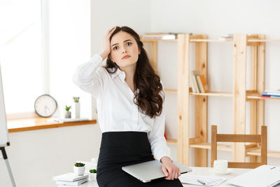 Portrait of depressed young woman at office