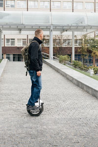 Man riding fast on electric unicycle on city street. mobile portable individual transportation