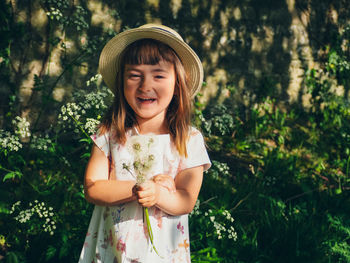 Portrait of smiling girl standing against plants