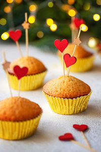 Saint valentine's day dessert, cupcakes decorated with wooden hearts on white table. front view. 