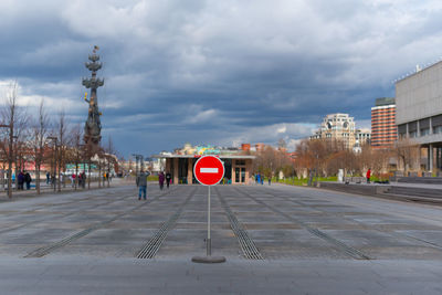 Road sign in city against sky