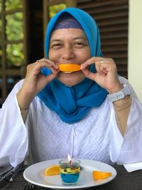 Portrait of woman eating fruit at cafe