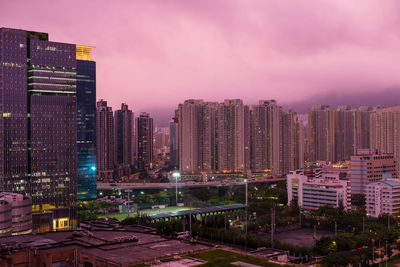 Illuminated buildings in city against sky at night