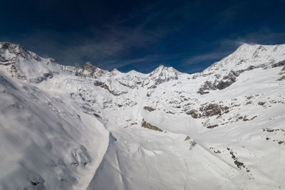 Scenic view of snow covered mountains against sky