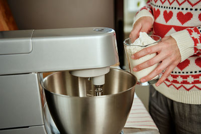 Woman cooking at home kitchen, use electric mixer to preparing dough