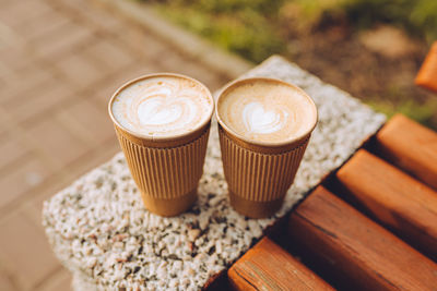 Two paper cups of cappuccino with latte art. beautiful foam, coffee to go