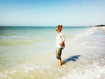 Full length of woman standing on beach against sky