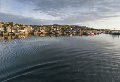 Houses by sea against sky