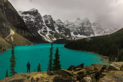 Scenic view of lake by snowcapped mountains against sky