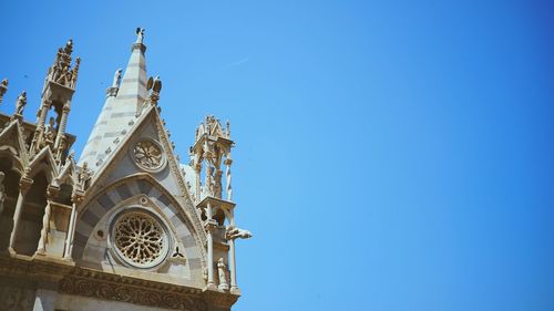 Low angle view of bell tower against blue sky