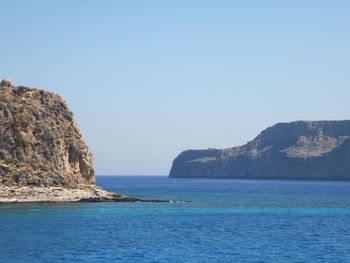 Scenic view of sea and rock formation against clear sky