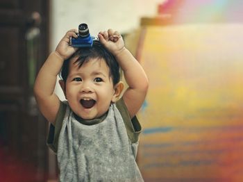 Portrait of cute boy holding camera