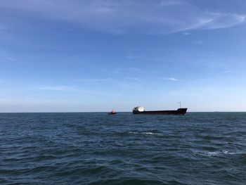 Boat sailing in sea against blue sky