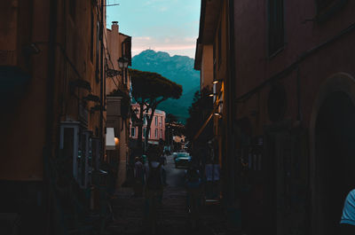 People walking on street amidst buildings in city