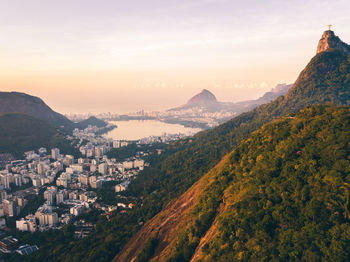 Scenic view of townscape and mountains against sky at sunset