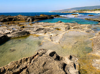 Rocks on beach against sky