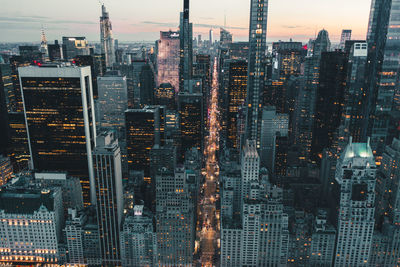 Aerial view of illuminated buildings in city at dusk