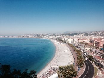 Aerial view of city by sea against clear blue sky