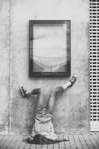 Girl leaning on wall with feet up