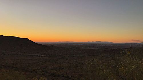 Scenic view of desert against clear sky during sunset