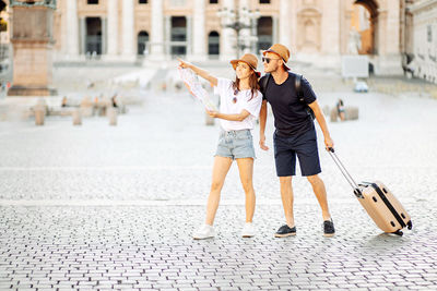 Happy tourists looking at a map and choose a hotel. couple of tourists on vacation in rome