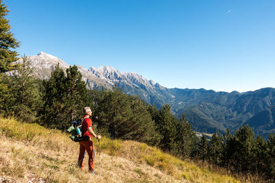 Full length of man climbing on mountain against clear sky