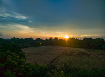 Scenic view of field against sky during sunset