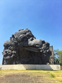 Low angle view of statue against clear blue sky