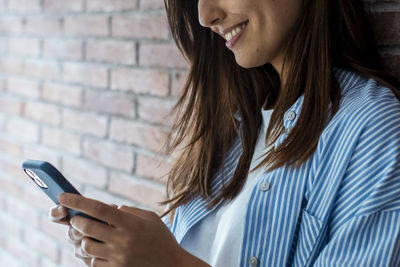 Midsection of woman using mobile phone