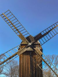 Low angle view of traditional windmill against clear blue sky