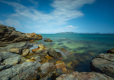 Scenic view of rocks in sea against sky