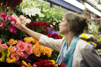 Woman checking flowers at market stall