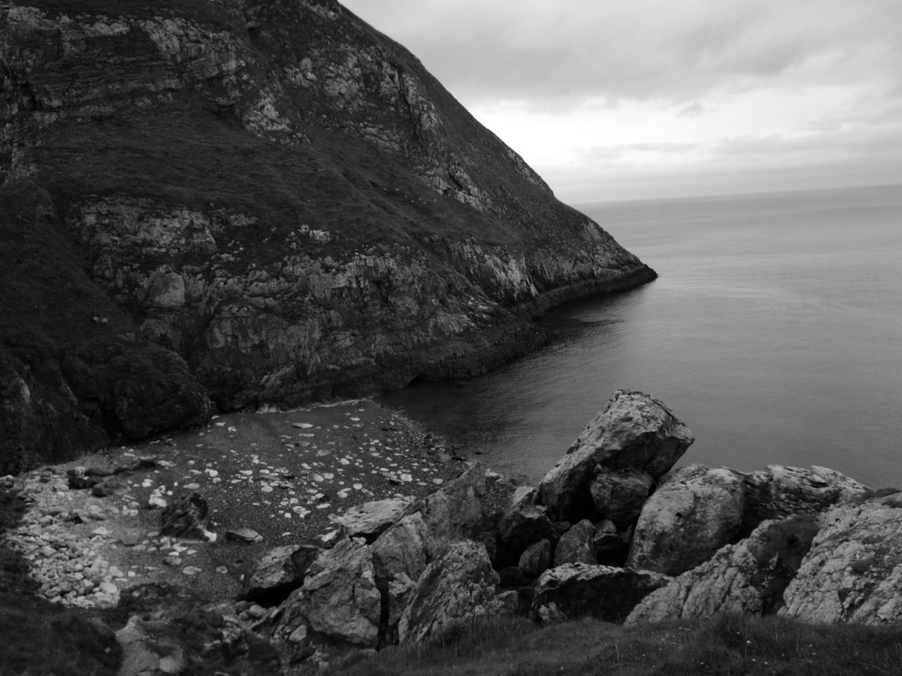 water, tranquil scene, tranquility, scenics, sea, beauty in nature, sky, rock - object, rock formation, nature, rock, horizon over water, idyllic, mountain, cliff, non-urban scene, remote, cloud - sky, geology, rocky, cloud, day, outdoors, coastline, no people, non urban scene, physical geography, calm, landscape, cloudy, majestic, rippled