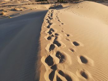 High angle view of footprints on sand