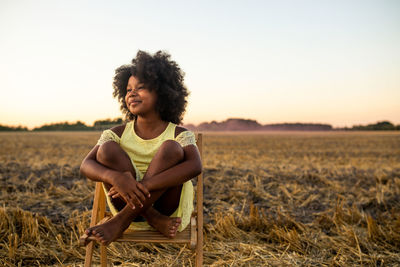 Cute girl sitting on field